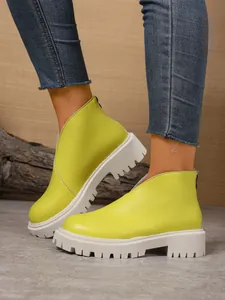 Detail shot of women's lime green platform ankle boots featuring a chunky lug sole