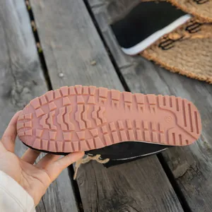 Detailed view of the textured non-slip sole of women's black suede slip-on loafer shoes