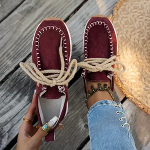 Close-up of burgundy suede loafers with decorative white stitching and thick hemp laces.