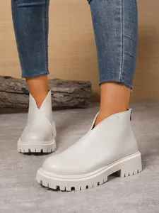 Detailed close-up view of women's beige platform ankle boots with front V-cut and lug sole.
