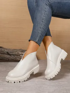 Fashionable cream women's chunky ankle boots featuring thick lug soles and V-cut front