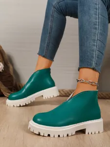 Emerald green leather ankle boots featuring thick white platform sole and stylish V-cut front
