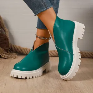 Fashionable teal ankle boots featuring thick white platform soles and chunky block heels