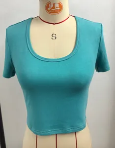 Gedetailleerd beeld van een turquoise katoenen crop top met ronde hals op een etalagepop model.