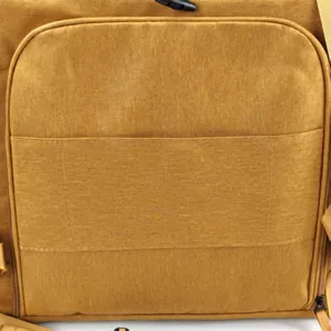 Detailopname van de duurzame gele canvas stof en stiksels van een draagbare kattenrugzak