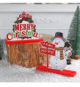 Detail view of wooden Christmas ornaments featuring snowman and Merry Christmas sign