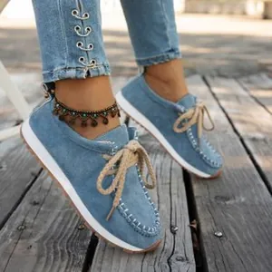 Detailed view of light blue denim loafers with ethnic style lace-up design