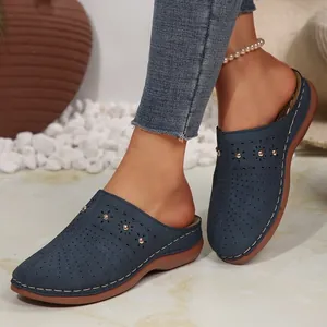 Vista dettagliata dei sabot blu da donna con motivi traforati e suole spesse