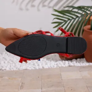 Detail view of the anti-slip black sole on a stylish red pointed-toe flat sandal.