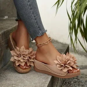 Vista detallada de sandalias de cuña nude con gran flor de tela decorativa arriba