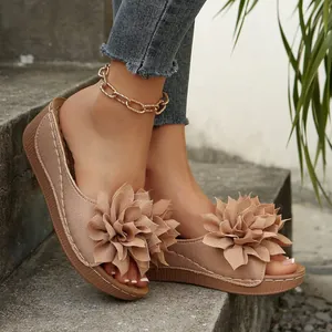Vista detallada de sandalias de cuña caqui con elegantes flores de tela en 3D.