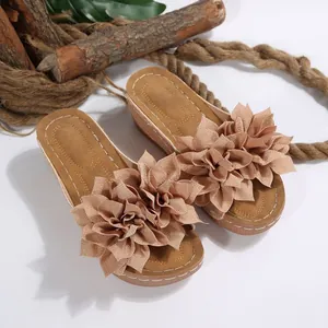 Vista detallada de sandalias de cuña bohemias con grandes flores de tela multicapa
