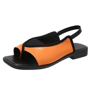 Close-up of stylish orange and black thong sandals with square toe and low block heel