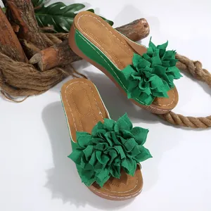 Vista detallada de flor de tela verde en sandalias de cuña de moda