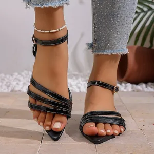 Elegant black pointed-toe flat sandals with multi-strap detail and ankle buckle
