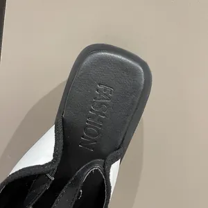 Macro view of the black insole with embossed Fashion text on a white sandal