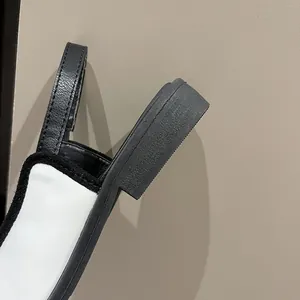 Close-up of black and white low block heel sandal with sturdy back strap detail.