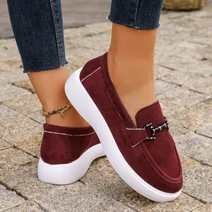 Primo piano di mocassino in pelle scamosciata bordeaux con fibbia in metallo e suola bianca