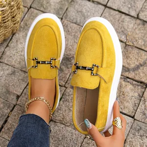 Eleganti mocassini in camoscio giallo con fibbia dorata e suola platform bianca.