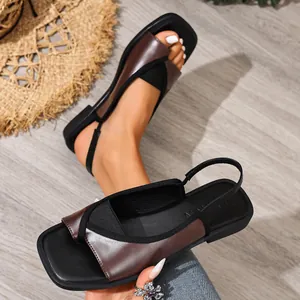 Detail of dark brown square-toe flat slingback sandals with black fabric straps.