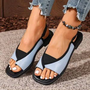 Detailed view of light blue square-toe slingback sandals on model with boho anklet.