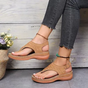 Detailweergave van stijlvolle boho-sandalen met sleehak in bruin met enkelbandjes