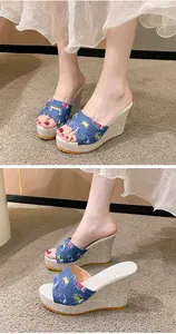 Détail de sandales compensées en denim avec broderie florale et plateforme paille