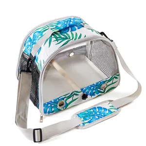 Portable bird carrier bag with tropical leaf pattern and wooden perch