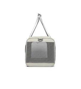 Detalle lateral de una bolsa de transporte para mascotas con malla gris y correa.