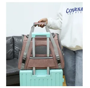 Detailed view of the pink pet carrier bag secured on a suitcase handle for easy travel