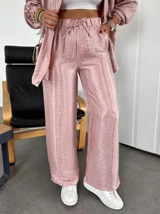 Detail view of pink shiny metallic wide-leg trousers with elastic drawstring waist