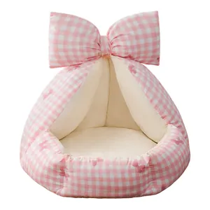 Cama para gatos semicerrada de cuadros rosas con un gran lazo decorativo.