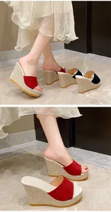 Détail élégant de sandales compensées rouges pour femmes avec semelle en paille.