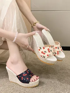 Détail rapproché de sandales compensées élégantes avec imprimé cerises et plateforme chic