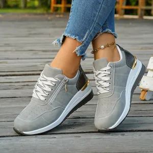 Vue détaillée de baskets grises pour femmes avec fermeture éclair latérale et semelle compensée