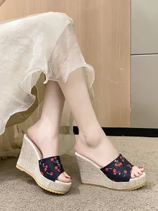 Détail de sandales compensées pour femmes avec imprimé cerise et plateforme tissée