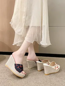 Vue détaillée des sandales compensées avec des motifs cerises et des talons en paille.