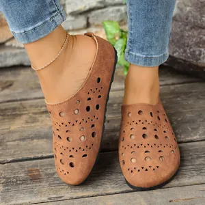 Dettaglio di ciabatte platform marroni con design traforato a laser geometrico trendy