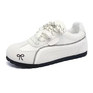 Profilo laterale di una sneaker German Trainer bianca con fiocco nero e cuciture