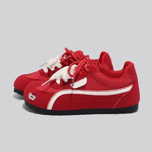 Vista laterale di scarpe da ginnastica rosse stile GAT donna con strisce e ricamo mela