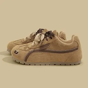 Vista dettagliata di sneakers in camoscio marrone con design a cuciture ondulate