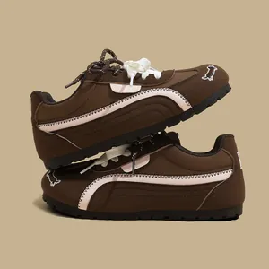 Dettaglio di sneaker casual marroni con striscia laterale e ricamo a forma di cane sulla punta