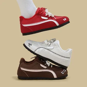 Tre sneaker casual da donna impilate in rosso, bianco e marrone con strisce laterali curve