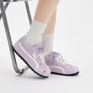 Dettaglio delle sneakers viola stile trainer tedesco da donna con ricamo di ciliegie