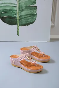 Close-up of pink platform flip-flops with vintage gold B-letter hardware detail