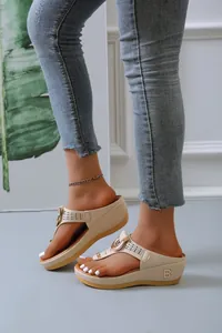 Detail of beige platform thong sandals with cutout straps and metallic ornament