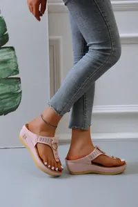 Detail view of pink wedge thong sandals with hollow-out design and a metal B logo