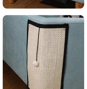 Close-up view of a durable sisal cat scratching mat protecting a blue sofa corner with a toy ball