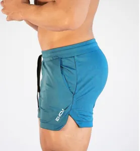 Detailed side view of teal quick-dry fitness shorts with white EHCM logo and leg slit
