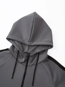 Close-up detail of gray hooded sports jacket with black zipper and drawstring
